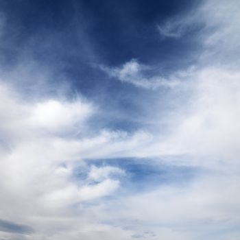 Wispy cloud formations against clear blue sky.