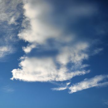 Wispy cloud formations against clear blue sky.