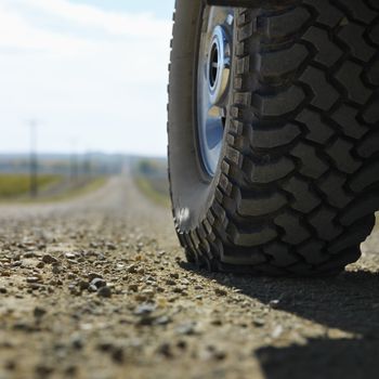 Low angle view of big truck tire on gravel road in rural South Dakota.