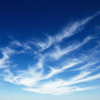 Wispy cirrus clouds in blue sky.