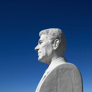 Bust of Ronald Reagan sculpture against blue sky in President's Park, Black Hills, South Dakota.