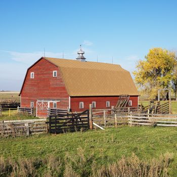 Red barn and fence in field.