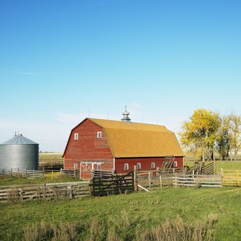 Red barn and fence in field.