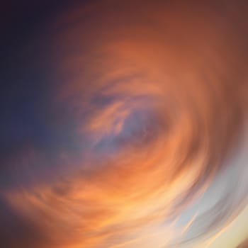 Spiral orange clouds in sky with sunset.