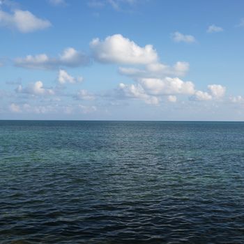 Calm water and blue sky with white puffy clouds in Florida Keys, Florida, USA.