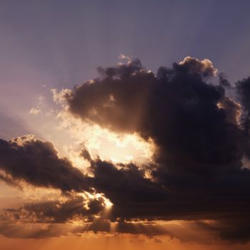 Sun shining through dark cloud.