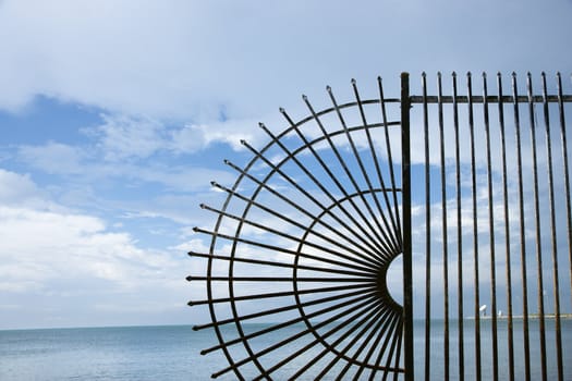 Decorative wrought iron fence at the edge of the sea.