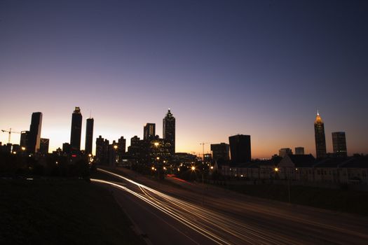 Nightscape of Atlanta, Georgia skyline with blurred automobile lights on highway.