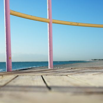 Pink and yellow painted railings of lifeguard tower on beach in Miami, Florida, USA.