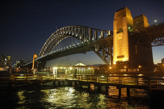 Harbour Bridge in Sydney; night scene; wooden wharf in foreground