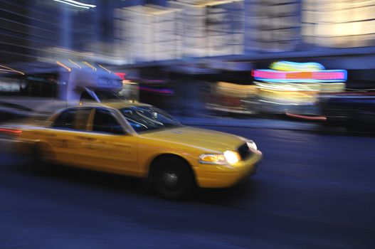 Taxicab rushing down a city street at night in a blur