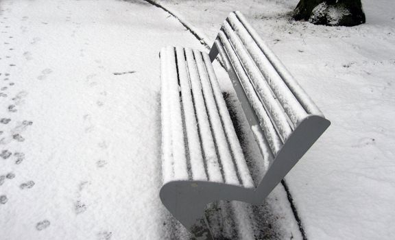 snow covered bench in a park                               