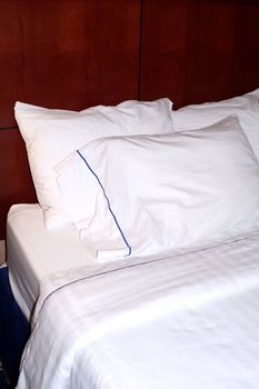 A hotel bed with clean, white linens