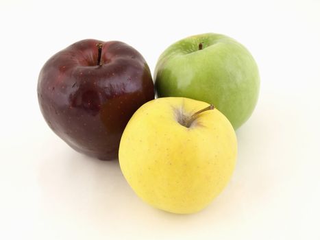 Three different colored apples in a grouping isolated on a white background