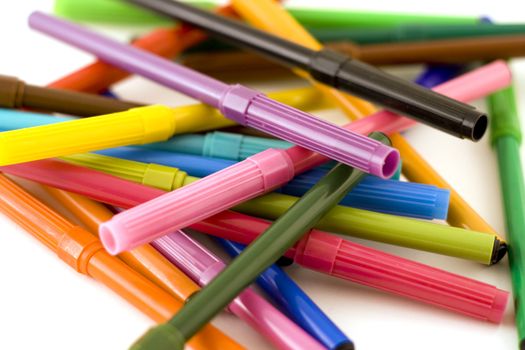 Pile of colorful markers on white background with shallow dof