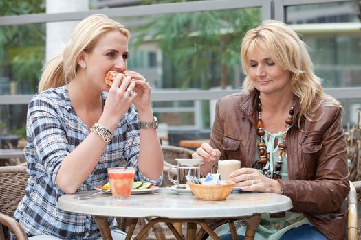 Mother and daughter having lunch together outdoors