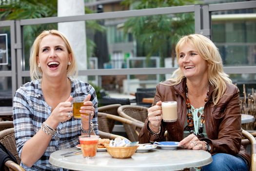 Mother and daughter on a terrace having a good laugh