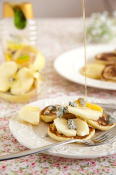 Delicious small pancakes with apple, gorgonzola and maple syrup
