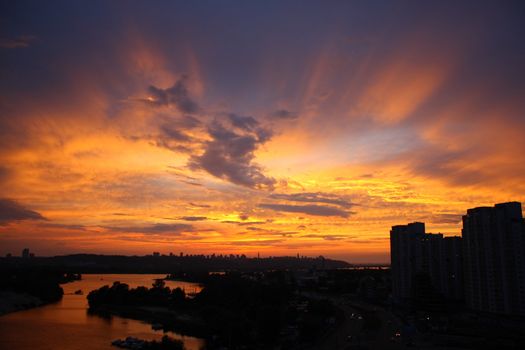 Silhouettes of the buildings and sunset rays in the sky.