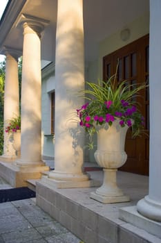 Main entry of old building with flowers at evening lights in Russia