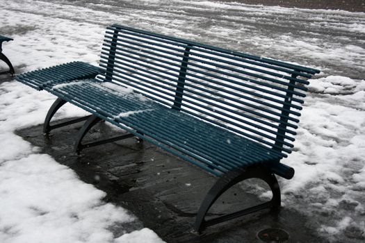 blue street bench in the snow