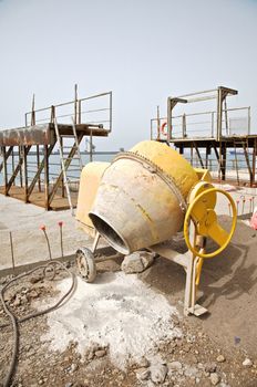 side view of a yellow working cement mixer