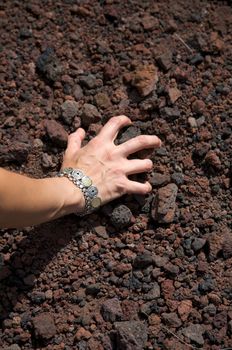 woman hand pick up volcanic stones