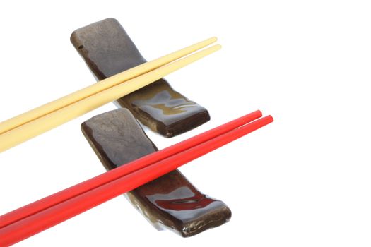 Two pair of colored chopsticks lying on rests. Isolated on white with clipping path