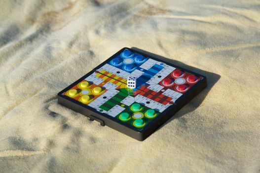 Parcheesi prepared on a yellow towel at the beach