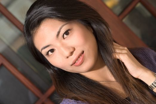 Asian woman portrait with black hair and yellow skin.
