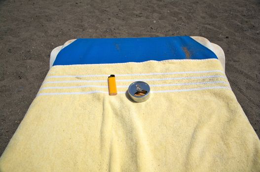 portable full ashtray with lighter on an hammock beach