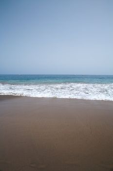 sea on brown sand at tejita beach in tenerife