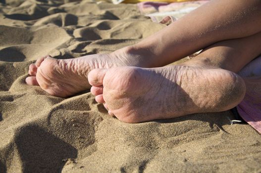 nude sole of two woman feet at the beach