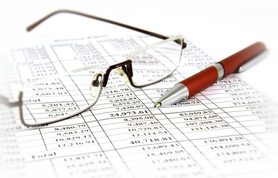 Financial report with pen and glasses on it