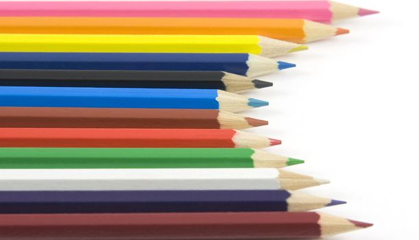 Collection of coloured pencils as arc on white background