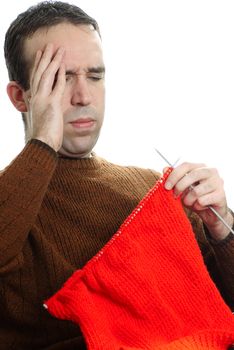 A young man is getting frustrated at his knitting, isolated against a white background