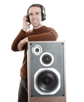 A young man wearing headphones and leaning on a large speaker, isolated against a white background