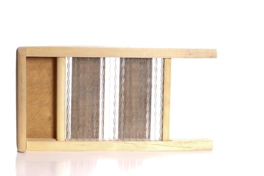 An old washboard made of glass and wood, isolated against a white background