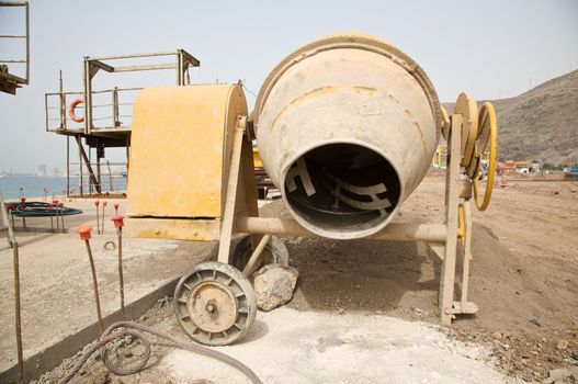front view of a yellow working cement mixer