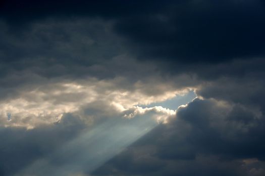 Ray of the sunlight between storm clouds