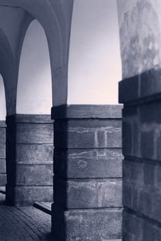 Medieval stone columns in blue tones. A colonnade in the historical centre of Prague.