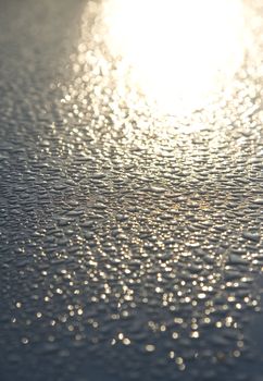 Water droplets on a metallic car paint.