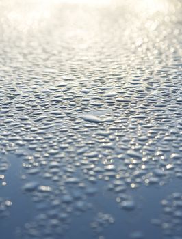 Water droplets on a metallic car paint.