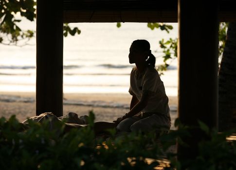 The girl-masseur in Bali salon on sunset