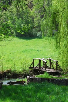 small woodden bridge on a creek in a countryside