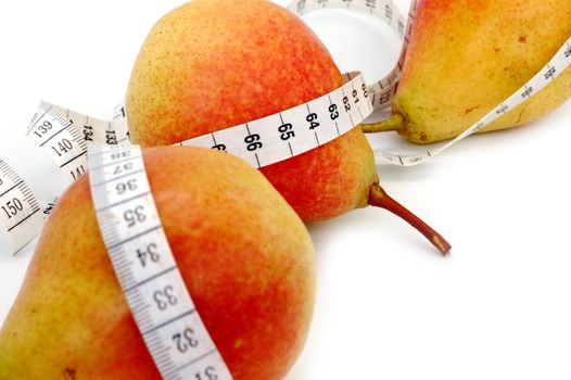 concept of healthy diet - three fresh pears and measuring tape