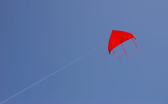 a red kite is flying in a blue sky