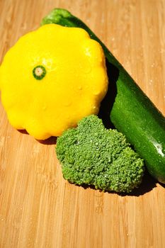 Fresh Broccoli , Zucchini and Patty Pan squash on a Bamboo cutting board