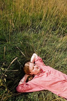 A country farm girl relaxing in the grass
