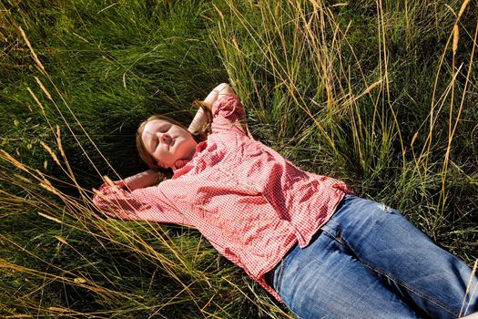 A country farm girl relaxing in the grass